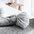 Narzuta wełniana z pomponami jasnoszara